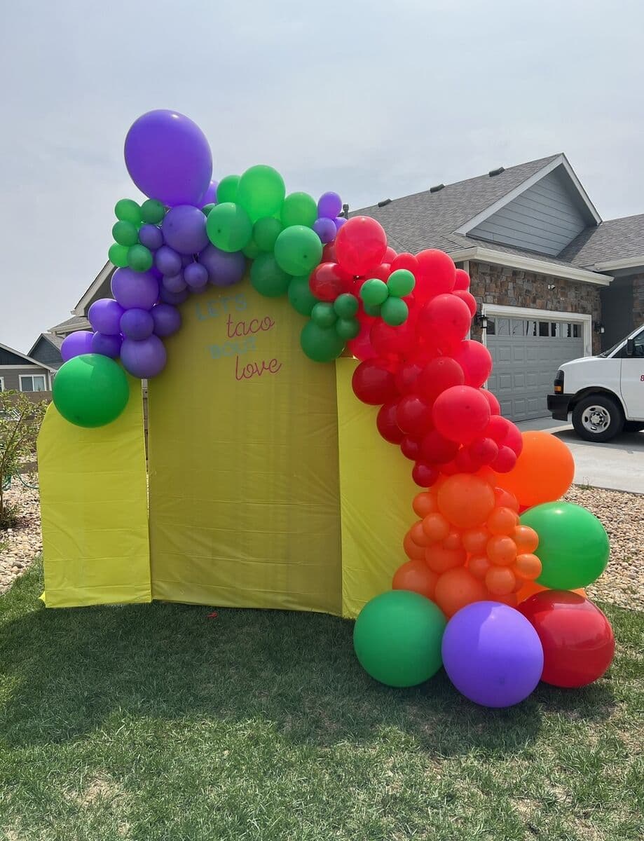 Custom backdrop framed by a rainbow balloon garland