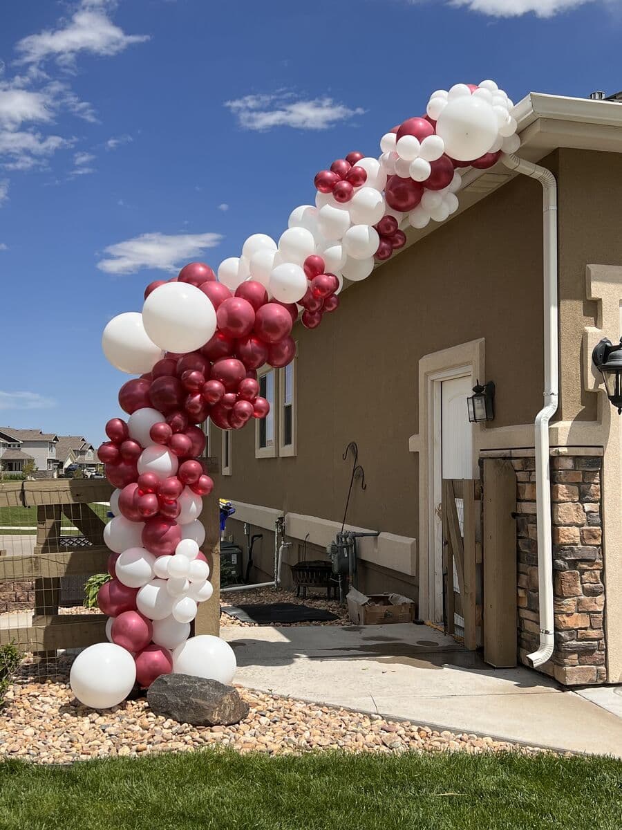 Burgundy and white balloon garland on a front porch